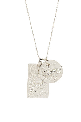 close-up-front-view-of-spell-s-leo-stargazer-zodiac-necklace-charms-one-charm-is-of-a-rectangular-shape-and-features-a-sun-with-stars-while-the-other-charm-is-circular-and-features-the-zodiac-label-and-icon